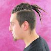 Junger Mann mit gepflegten und geflochtenen Dreadlocks mit Undercut